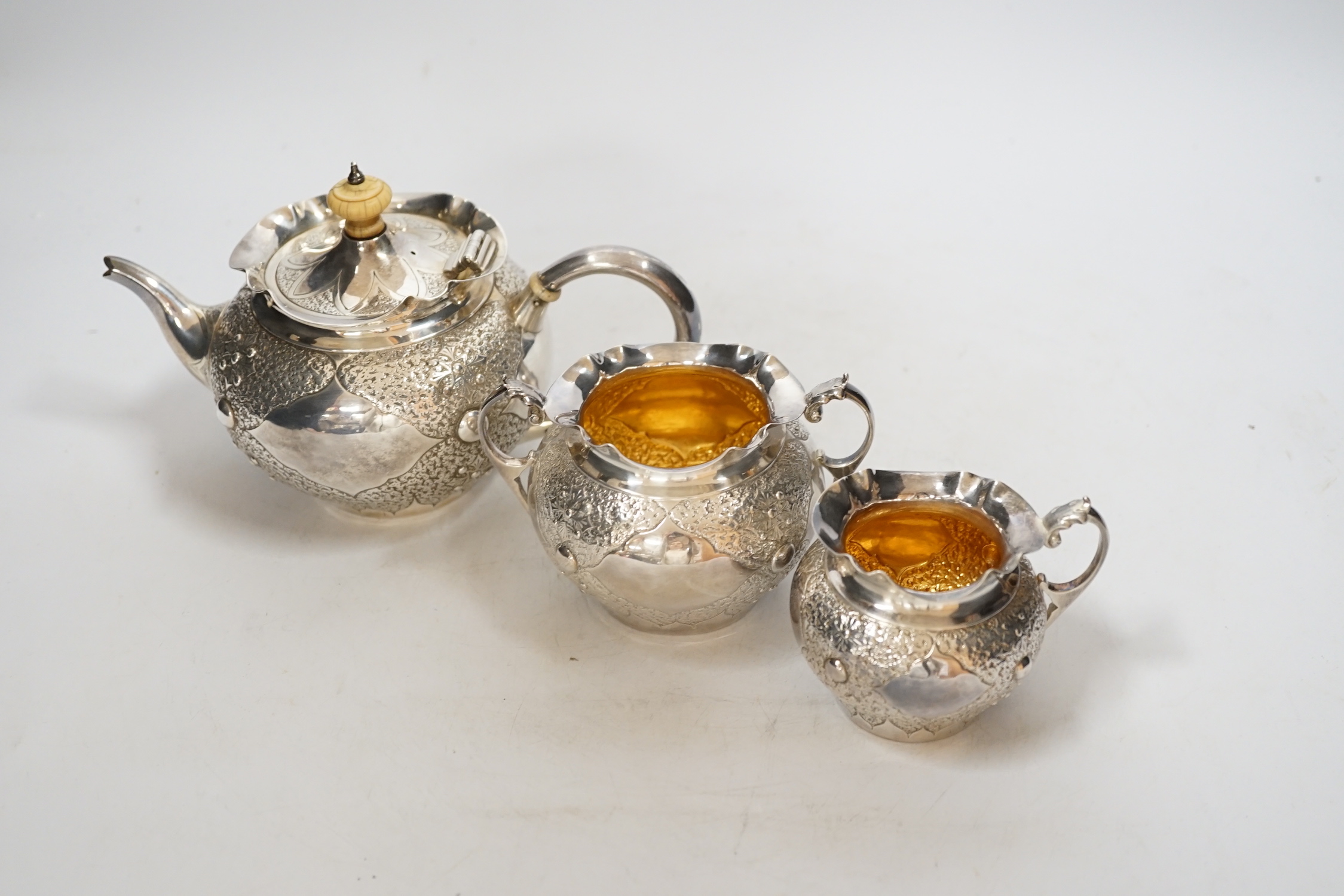 A Victorian embossed silver three piece bachelors tea set, Charles Edwards, London, 1880, gross weight 17.9oz., CITES Submission reference WAD4FJG4